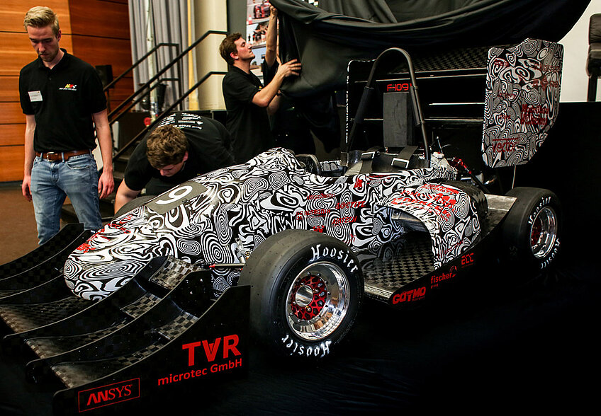 students in front of the racing car 